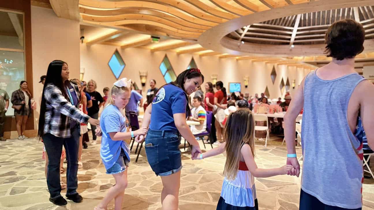 A group of people holding hands and dancing.
