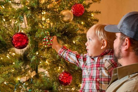 Father and son looking at a Christmas tree